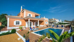 Une maison avec une piscine, un espace extérieur aménagé et un jardin.