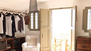 Une chambre à coucher comprenant un lit, une chaise, une armoire et un portant à vêtements.