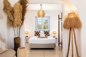 A bedroom with a bed, bedside lamps, a window, and a door.