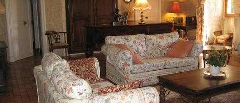 A cozy living room with floral-patterned sofas, a wooden coffee table, and a decorative lamp.