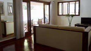 A living room with a sofa, a television, and a sliding glass door leading to an outdoor area. - A Few Steps From The Gorgeous Beach Of Punta Rucia! (Punta Rucia)
