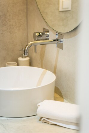 A bathroom with a white sink, a towel, and a mirror. - Villa Nayana - Shoreline Calm by etouri (Rethymno)