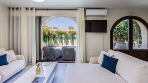 Une chambre d’hôtel comprenant un lit, deux canapés, une télévision et un balcon avec des meubles d’extérieur.