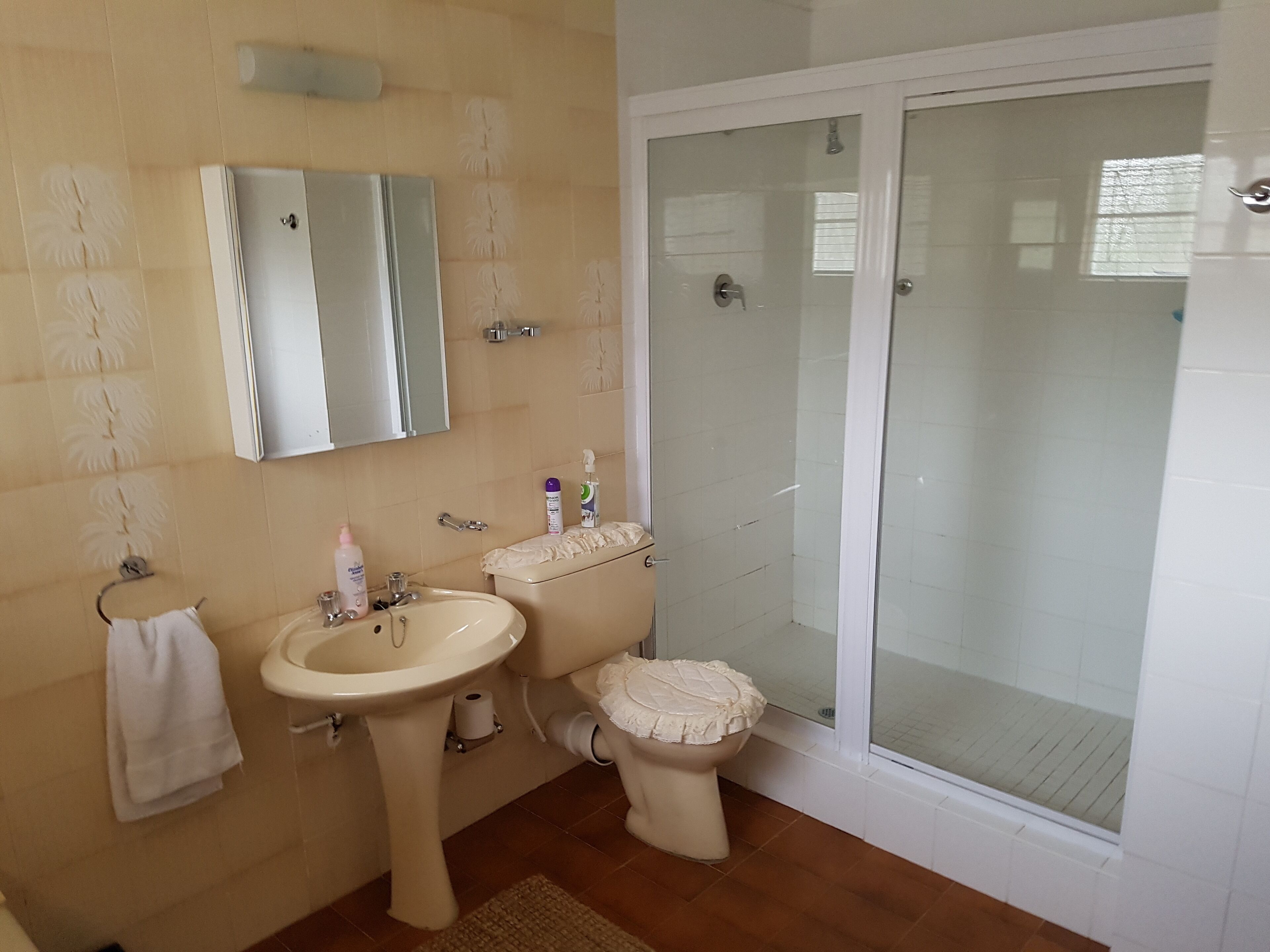 A bathroom with a sink, toilet, and glass-enclosed shower.