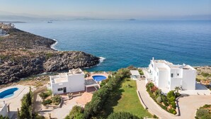 A coastal property with a swimming pool, white buildings, and a rocky shoreline. - Villa Phaedra 7 bedroom villa (Tersanas)