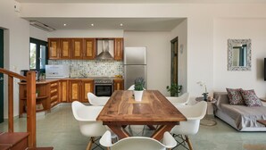 A modern kitchen with wooden cabinets, a stainless steel range hood, and a built-in oven. - Villa Phaedra 7 bedroom villa (Tersanas)