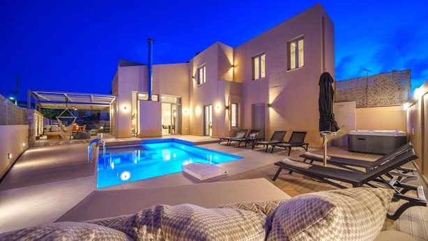 A modern outdoor pool area with lounge chairs and a hot tub, surrounded by a contemporary building with multiple windows and a covered seating area. - Luxury, Spacious Villa with private gym, just 4km from the sandy beach! (Πηγή)