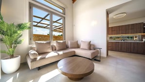A modern living room with a sectional sofa, a round coffee table, and a potted plant. - Luxury, Spacious Villa with private gym, just 4km from the sandy beach! (Πηγή)