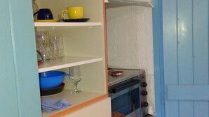 Uma cozinha compacta com forno embutido, micro-ondas e uma bancada pequena.