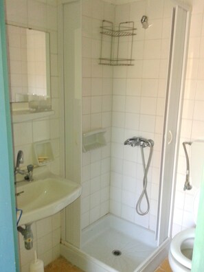 A bathroom with a shower, sink, and toilet.
