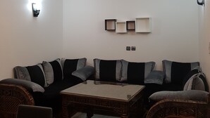 A living room with a sofa, armchairs, a coffee table, and a wooden floor. - Flat three rooms furnished and equipped with air conditioning and wifi satelite (Agadir)