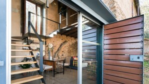 Un interior moderno con una escalera, una zona de comedor y un ventanal grande.