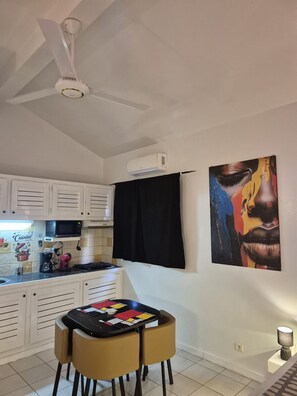 A kitchen with white cabinets, a microwave, a coffee maker, and a table with chairs.
