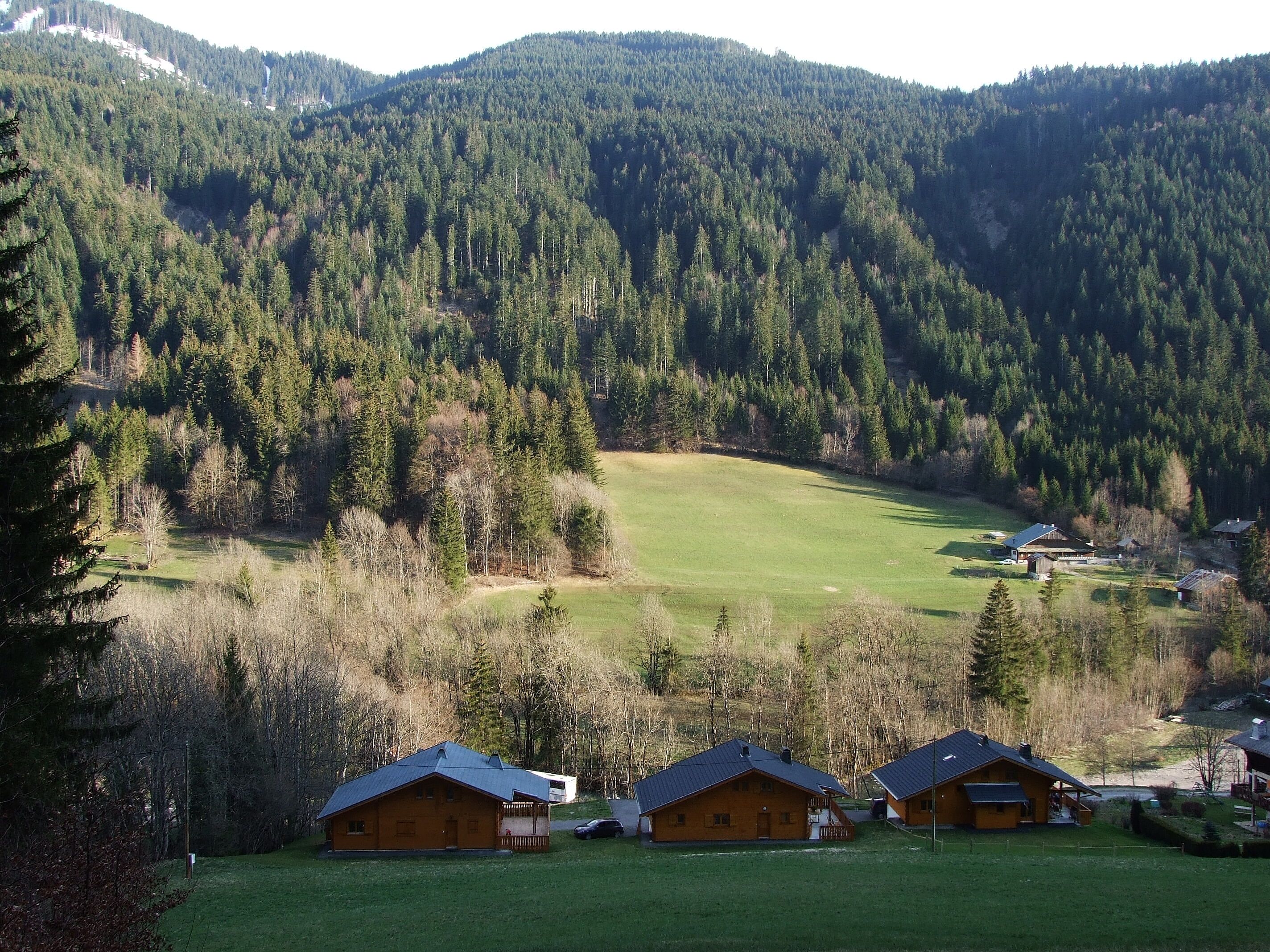 Eine Berglandschaft mit einer kleinen Gruppe Holzhütten.