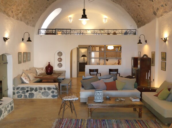 A cozy living room with a stone accent wall, a wooden coffee table, and a colorful rug.