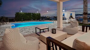 An outdoor pool area with seating and a sunset view. - New beautiful artistic  villa! 1km to the beach! (Gerani)