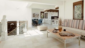 A spacious living area with a dining table, sofa, and a kitchen in the background. - New beautiful artistic  villa! 1km to the beach! (Gerani)