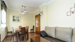 Un salon avec une table basse en bois, un canapé et une table à manger avec des chaises.