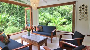 Una habitación con un ventanal grande, un sofá, una mesa y una silla.