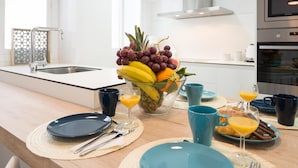 Een moderne keuken met een centraal kookeiland, een roestvrijstalen afzuigkap en een inbouwoven.