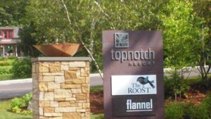 A sign for Topnotch Resort with logos for The Roost and Fannel. - 2BR Courtside at Topnotch Spa (Stowe)