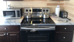 A kitchen with a stainless steel stove, microwave, and toaster.