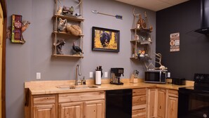 A kitchen with wooden cabinets, a dishwasher, a microwave, and a coffee maker. - GREEN HILL LODGE @ thegreenhilllodge.com (Fordland)