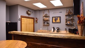 A kitchen with a wooden countertop, a sink, and a refrigerator. There are shelves with decorative items and a painting on the wall. - GREEN HILL LODGE @ thegreenhilllodge.com (Fordland)