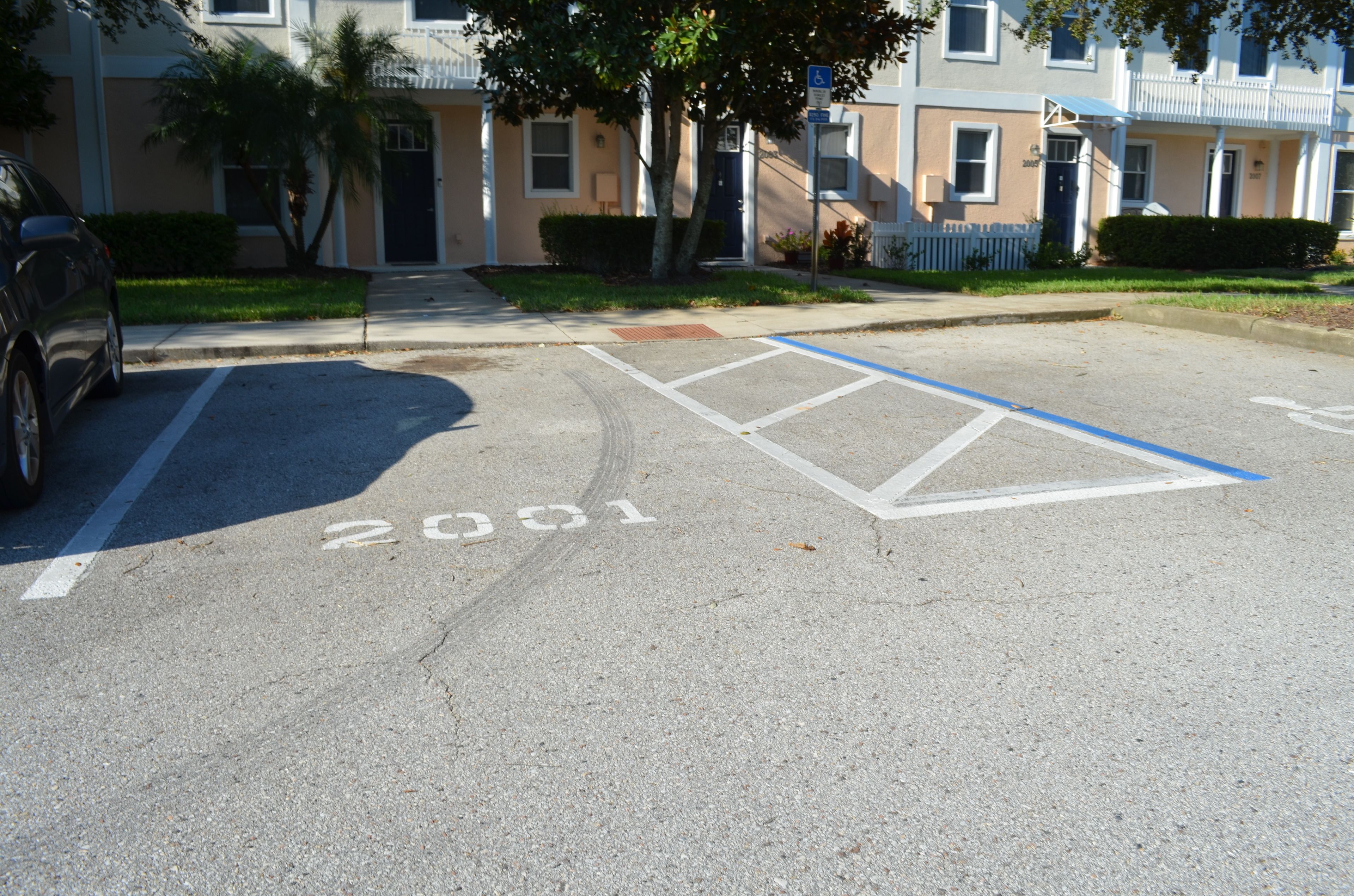 Posto auto contrassegnato dal numero '2001' e segnaletica per parcheggio riservato ai disabili.