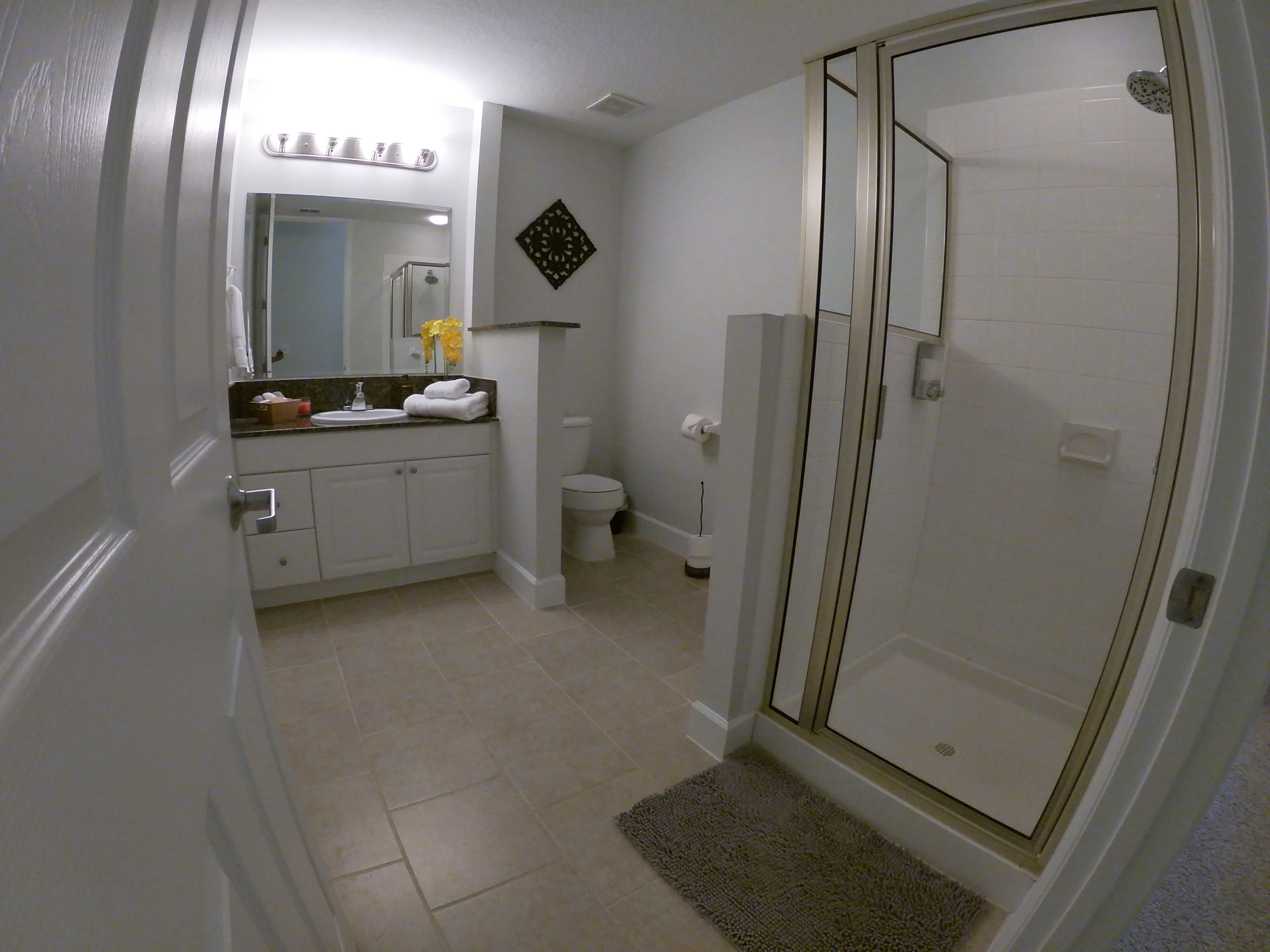 A bathroom with a shower, toilet, and sink.