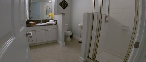 A bathroom with a shower, toilet, and sink.