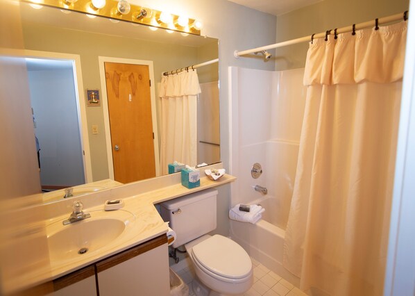 Un baño con lavamanos, inodoro y ducha.