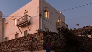 Un bâtiment avec un mur en pierre, un panneau indiquant qu’il est interdit de se garer et un escalier menant à l’entrée.