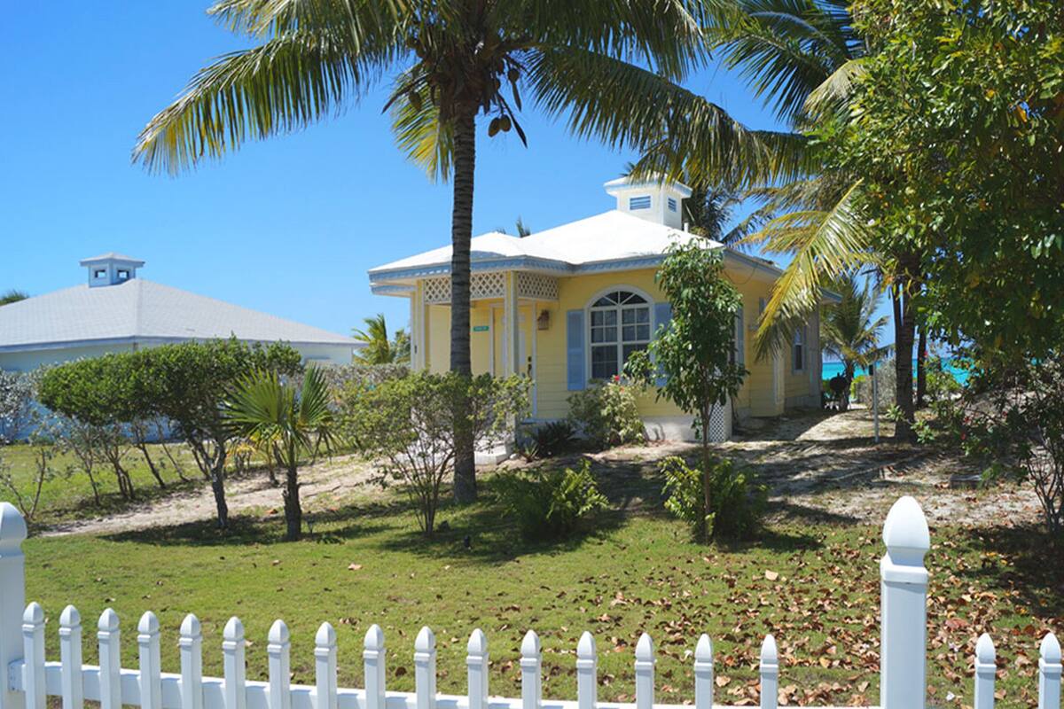 A yellow building with a white fence in front.