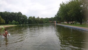 Une rivière paisible, avec un pont et des arbres en arrière-plan.