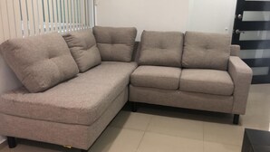 A beige sectional sofa with a curved design, positioned against a white wall with vertical blinds. - Beautiful and comfortable apartment (Residencial Zacatenco)