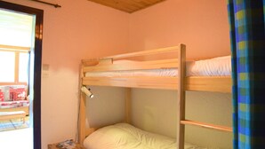 A bunk bed room with a small table and a lamp.