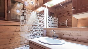 A wooden cabin bathroom with a sink, mirror, and shower curtain. - Cozy chalet for 10, fireplace, garage, WIFI, pets welcome (La Clusaz)