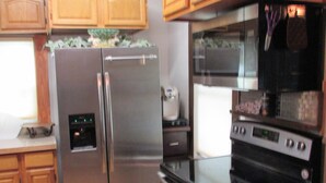 Una cocina con electrodomésticos de acero inoxidable, armarios de madera y horno empotrado.