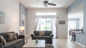 Ein Wohnzimmer mit einer Couch, einem Couchtisch und einem Deckenventilator.