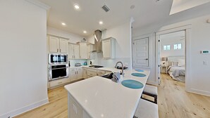 A modern kitchen with white cabinets, stainless steel appliances, and a central island.