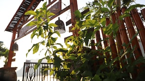 A wooden structure with a bell and a metal gate in the background. - Phong Nha Friendly Home 2 (Phong Nha)