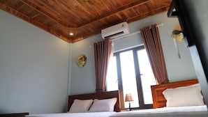 A bedroom with wooden ceiling, two beds, an air conditioner, and a window with curtains. - Phong Nha Friendly Home 2 (Phong Nha)