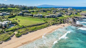 A coastal residential area with beachfront properties, a golf course, and a view of the ocean. - Molokai views, refreshed upgrades, relax comfort (Lahaina)