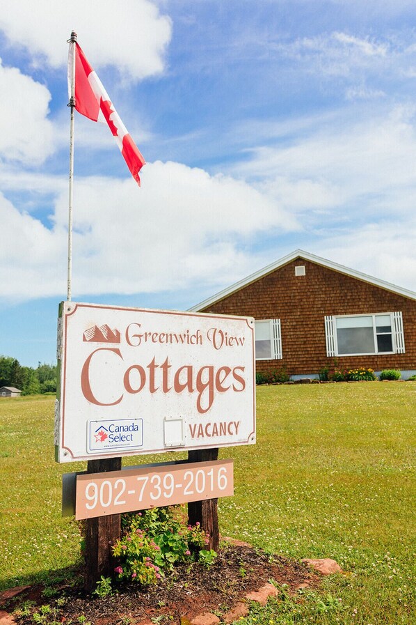 Naamplaatje voor Greenwich View Cottages, met een bericht over vrije kamers en een telefoonnummer.