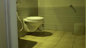 Un baño con inodoro, lavabo y zona de ducha.
