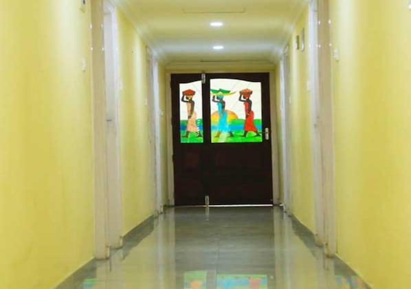 Un pasillo con un puerta doble que presenta obra de arte colorida.