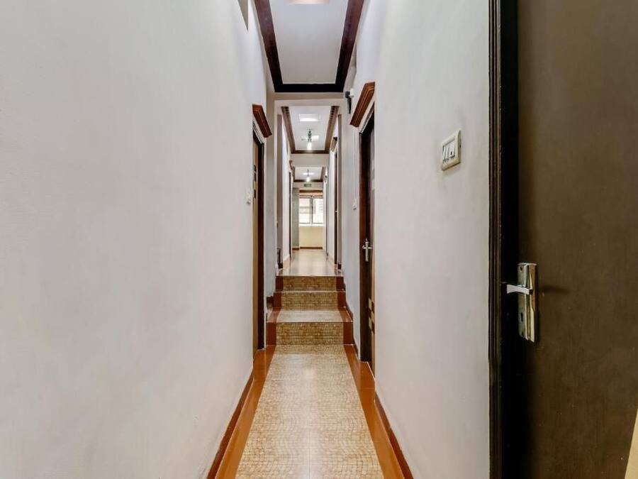 A hallway with a tiled floor, wooden trim, and doors on either side.
