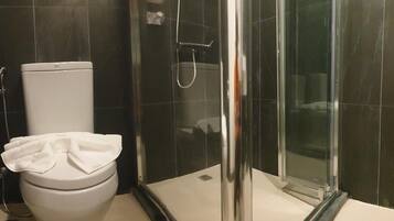 Chuveiro, toalhas de banho, shampoo, papel higiênico