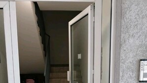 Eine offene Tür, die zu einer Treppe mit Fliesenboden führt.